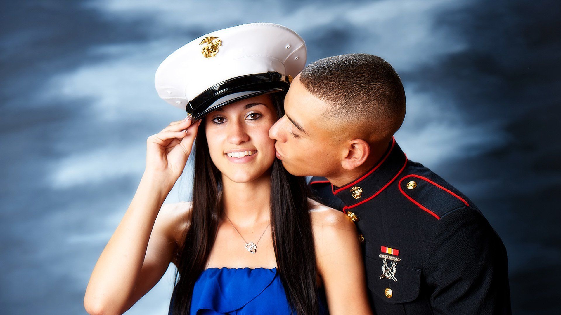 A man in a military uniform kisses a woman on the cheek