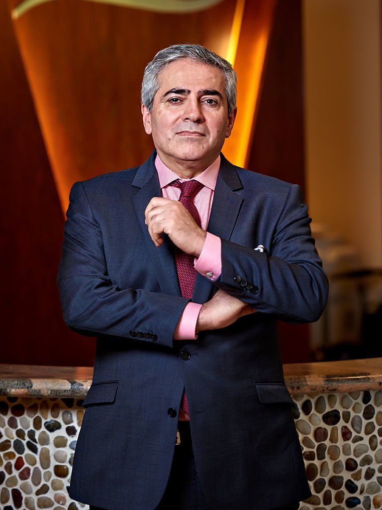 A man in a suit and tie is standing with his arms crossed.