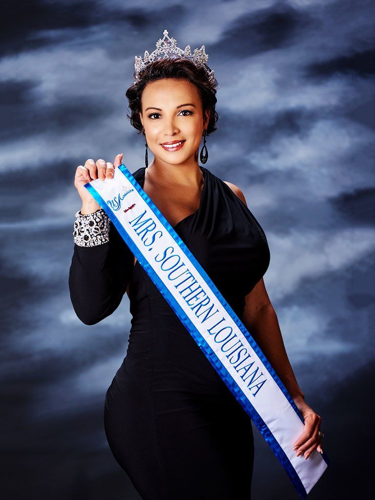 A woman is holding a sash that says miss southern louisiana