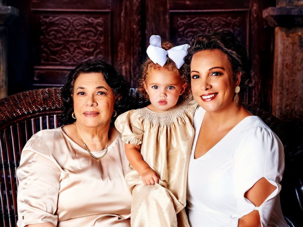 Two women and a little girl are posing for a picture.