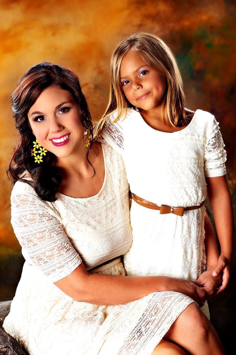 A woman and a little girl are posing for a picture