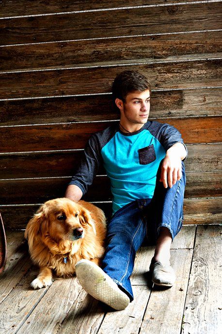 A young man is sitting on the floor with his dog