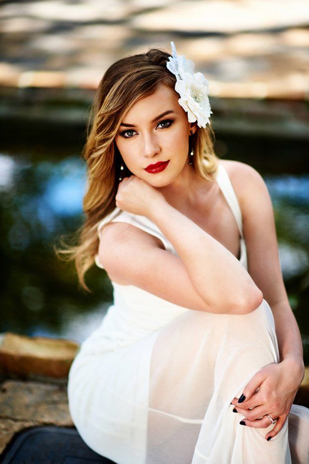 A woman in a white dress with a flower in her hair.