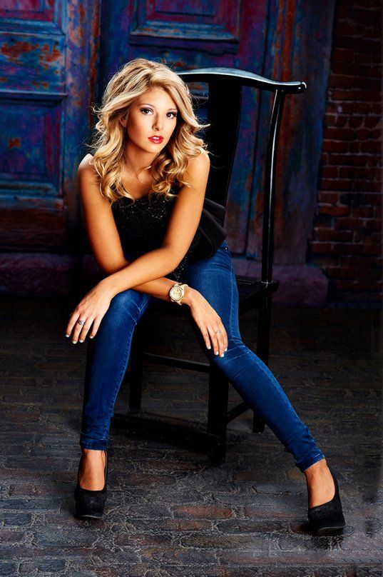 A woman is sitting on a chair with her legs crossed