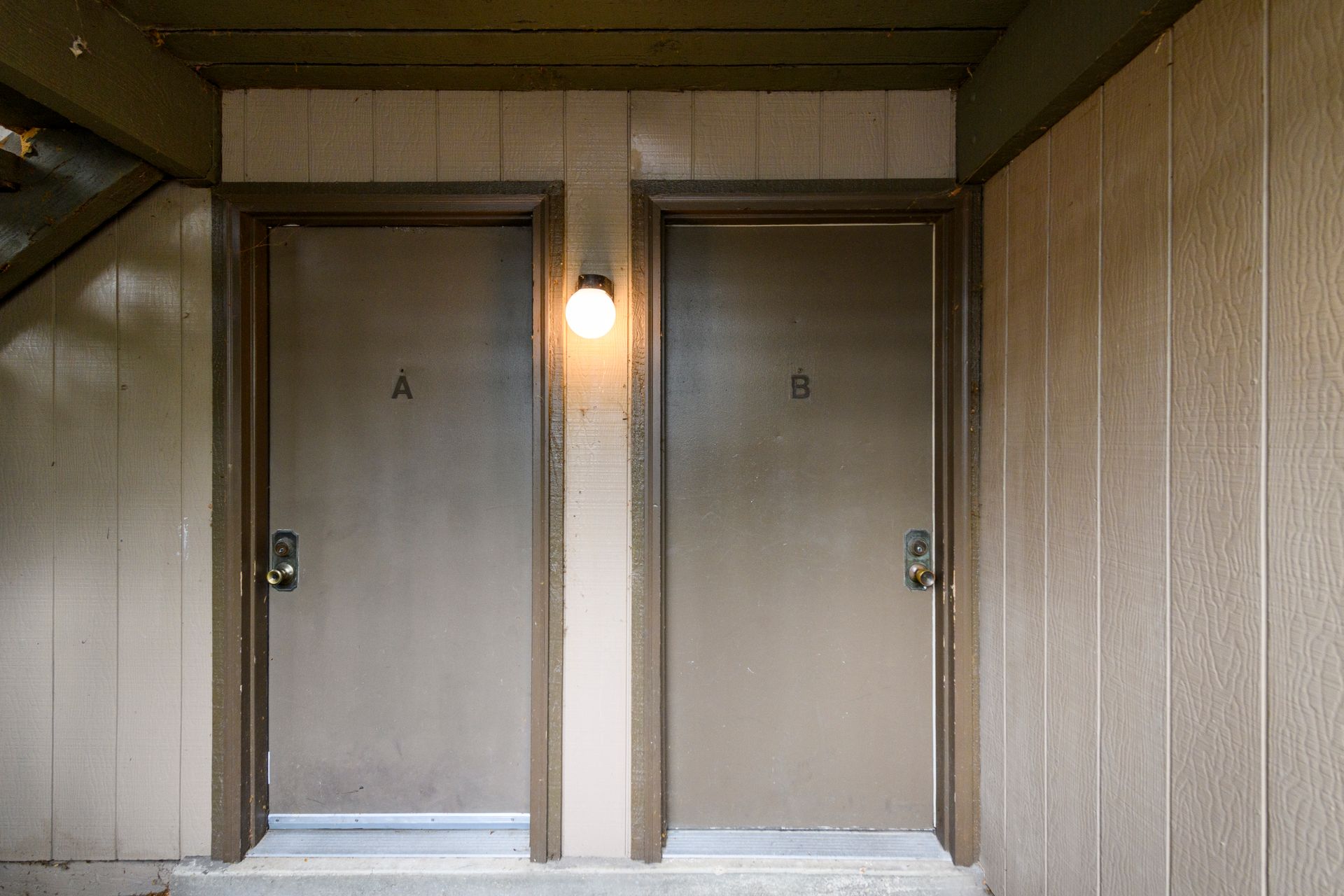 Two apartment doors labeled A and B with a light overhead.