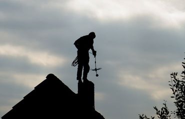 Chimney Sweeping — Man Cleaning Chimney in Northwest, IN