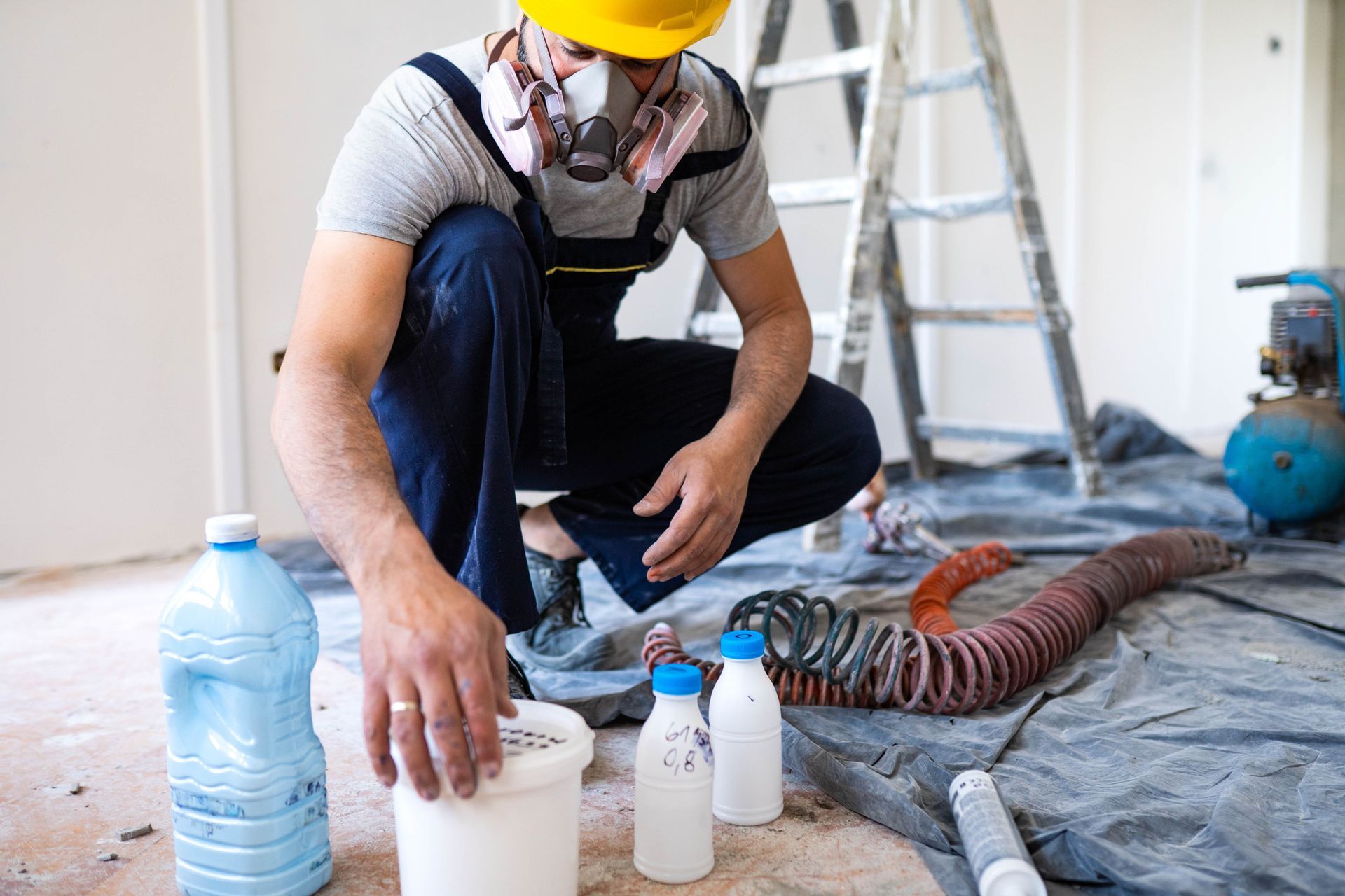 Young male construction worker preparing paint to work. Young male construction worker preparing paint to work.
