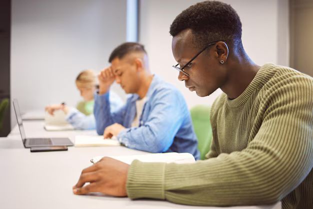 High-achieving Black college student sitting on campus, focused and reflective, representing mindful