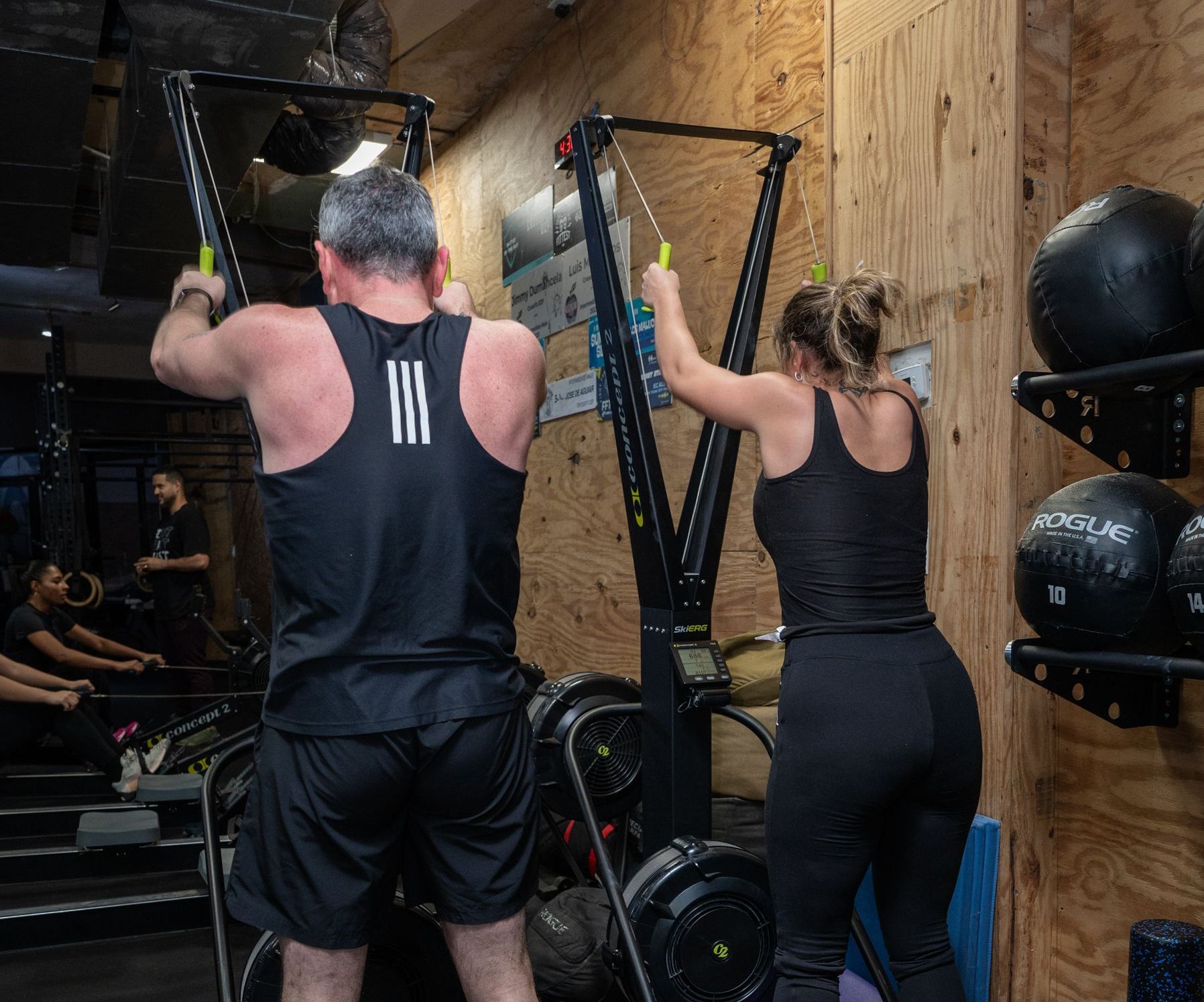 A man and a woman are doing exercises in a gym.