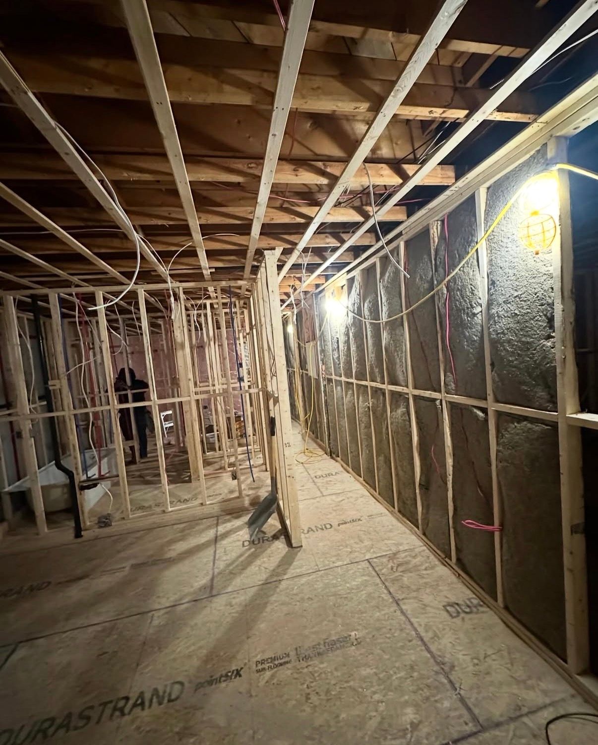 Vue intérieure d'une pièce en construction avec une ossature en bois et une isolation installée sur un mur.