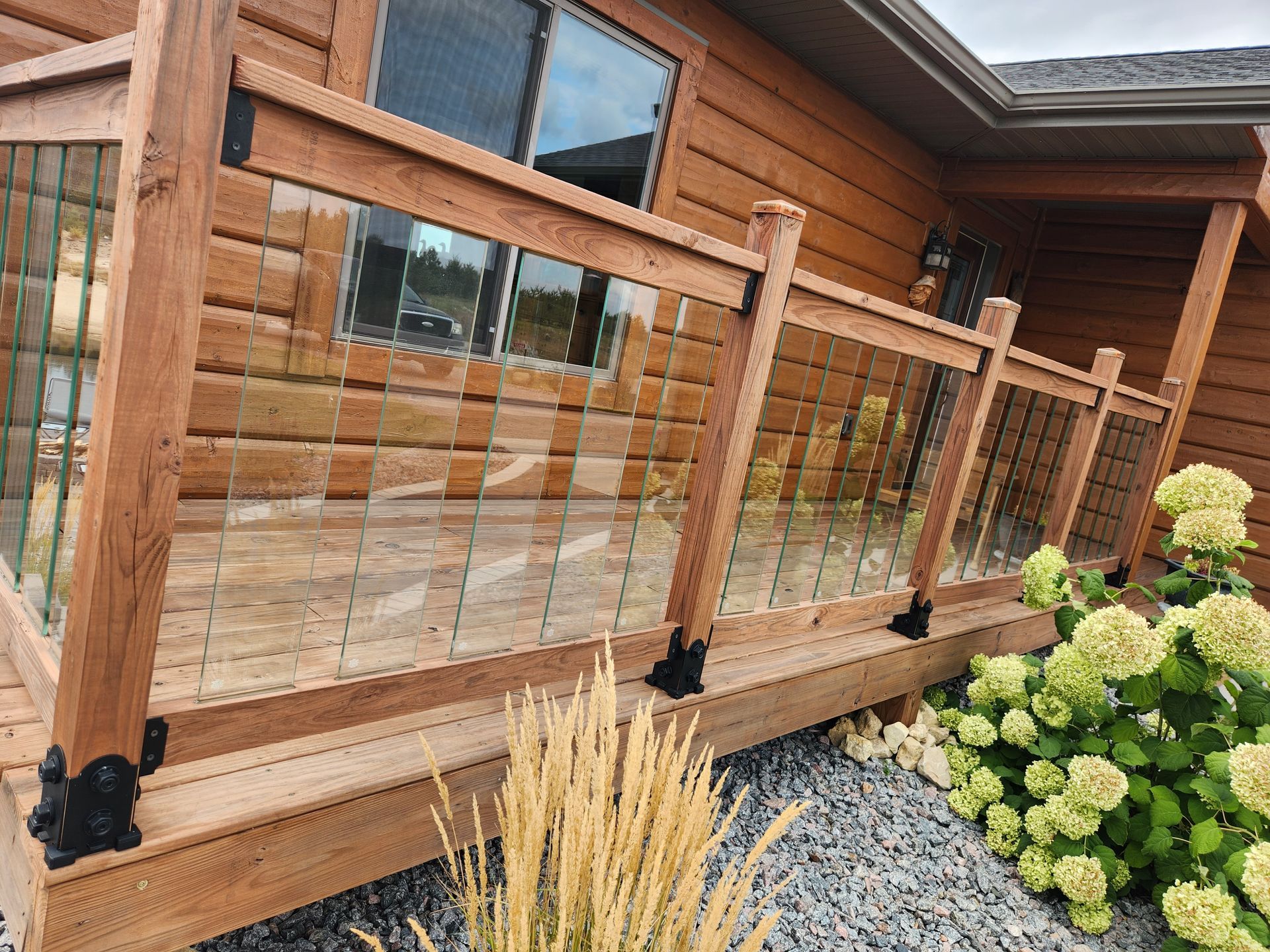 A can of wood stain and a brush on a wooden deck.