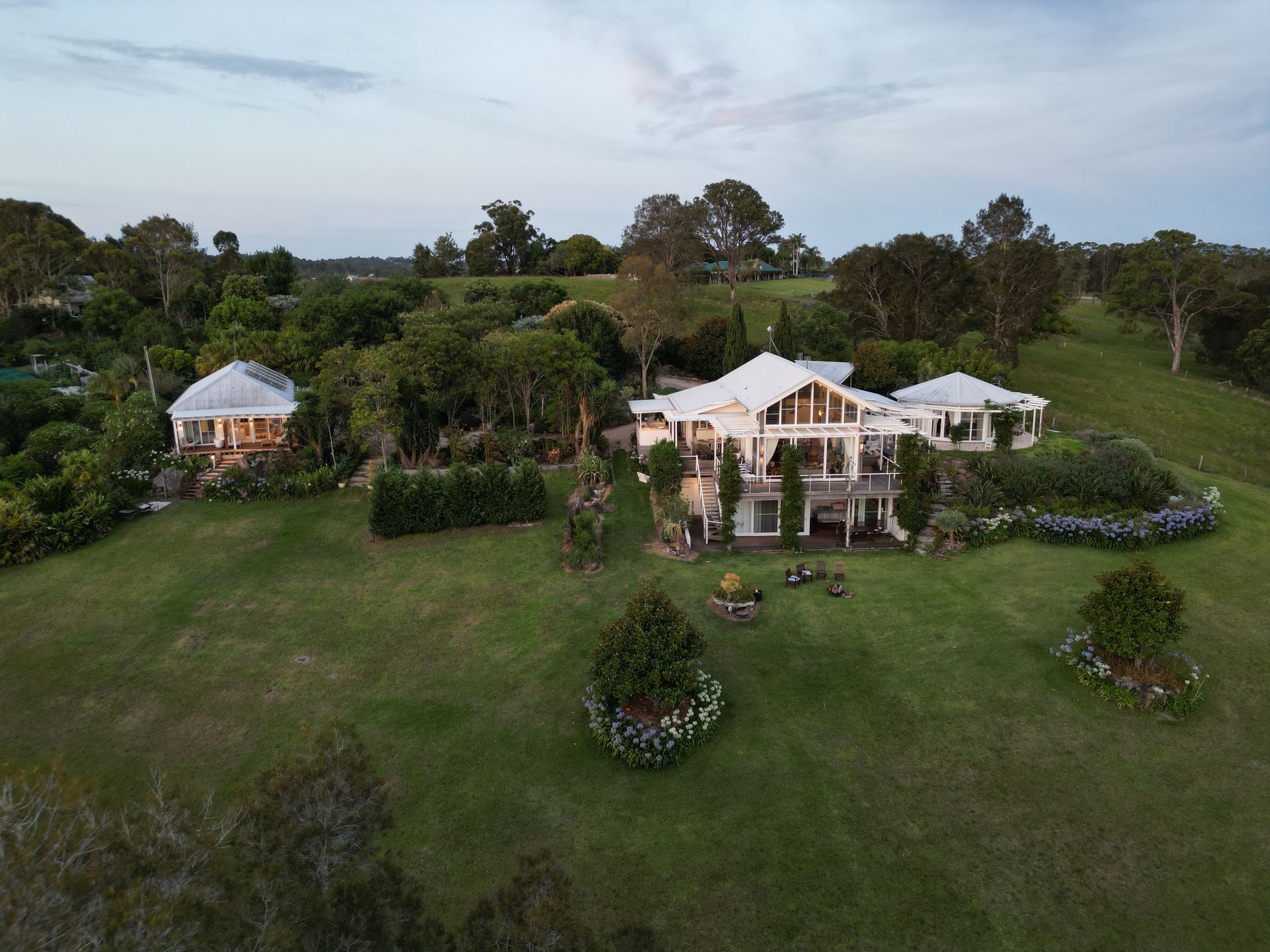 An aerial view of a large house surrounded by trees and grass.