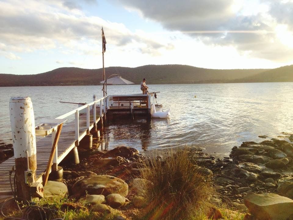 A boat is docked at a dock with mountains in the background