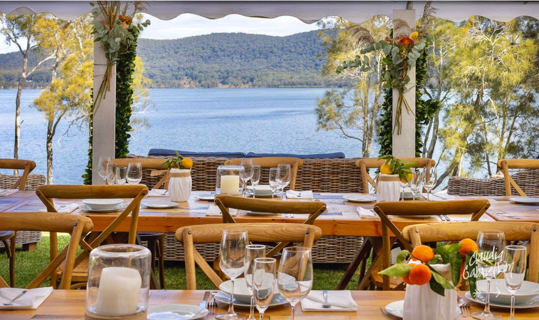 A table set for a wedding reception with a view of a lake.