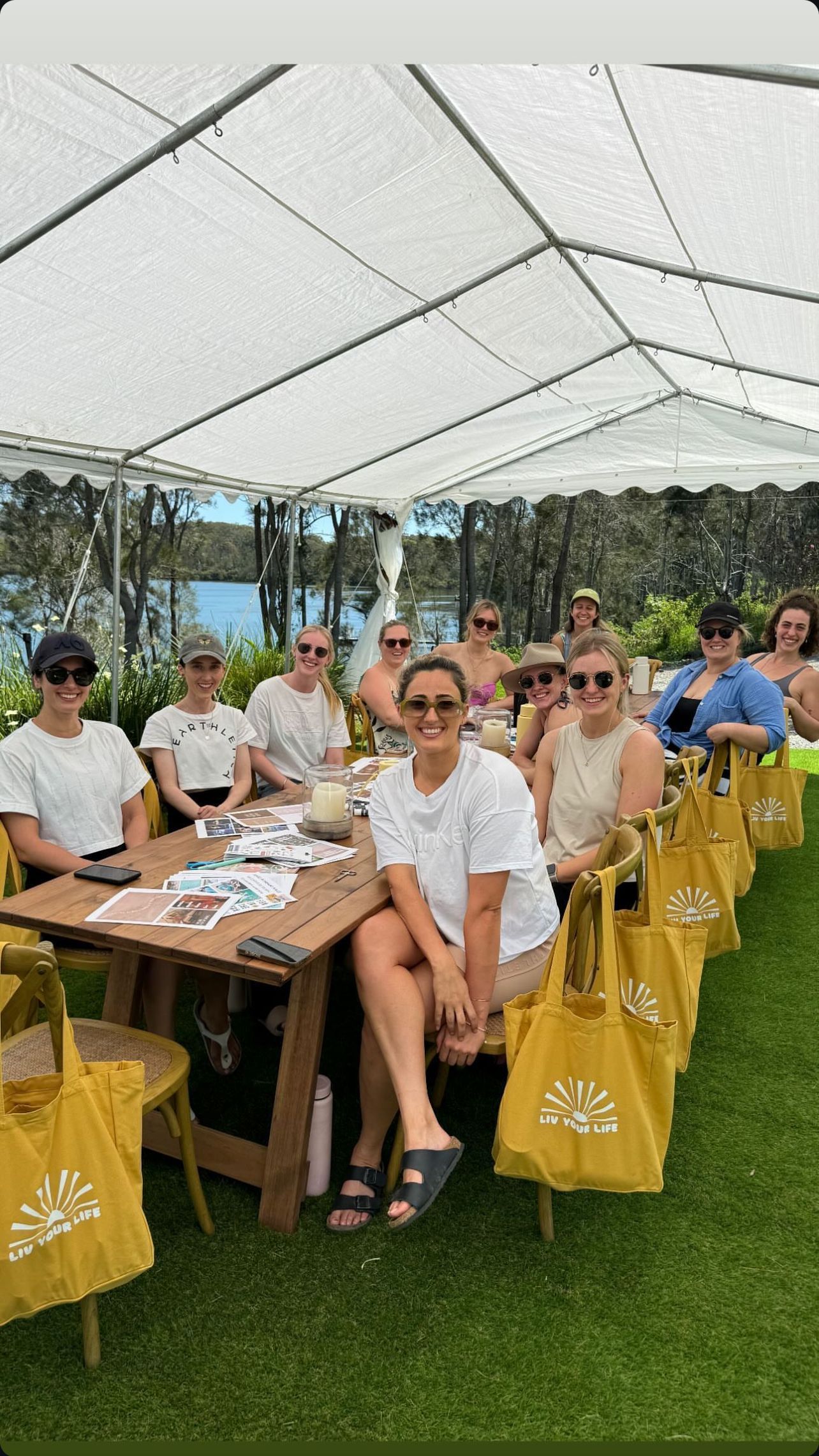 A group of people are sitting at a table under a tent.