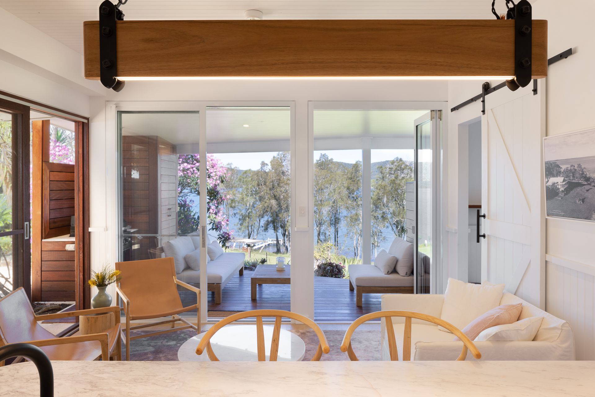 A living room with a table , chairs , couch and sliding glass doors.