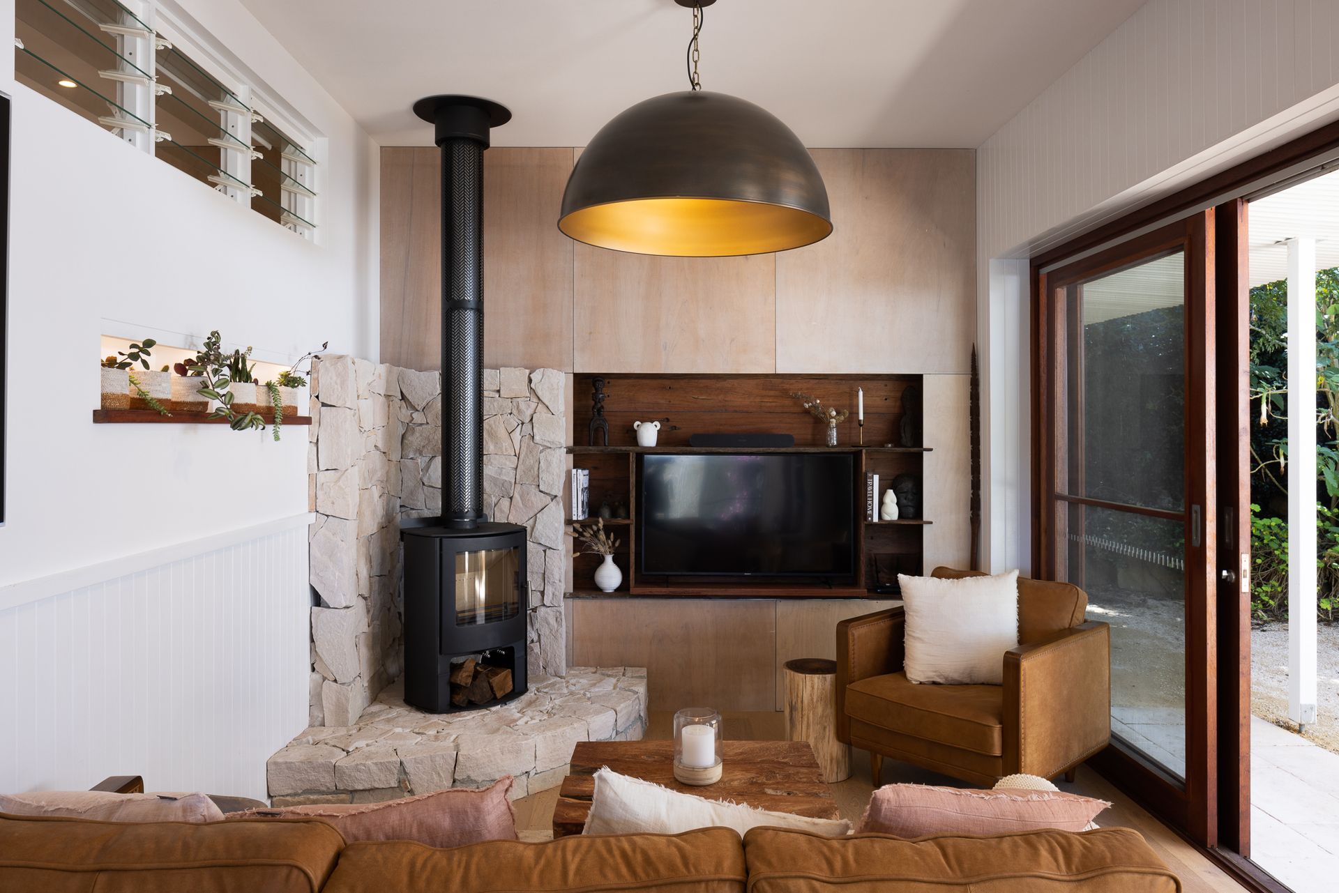 A living room with a fireplace , couch , chair and television.