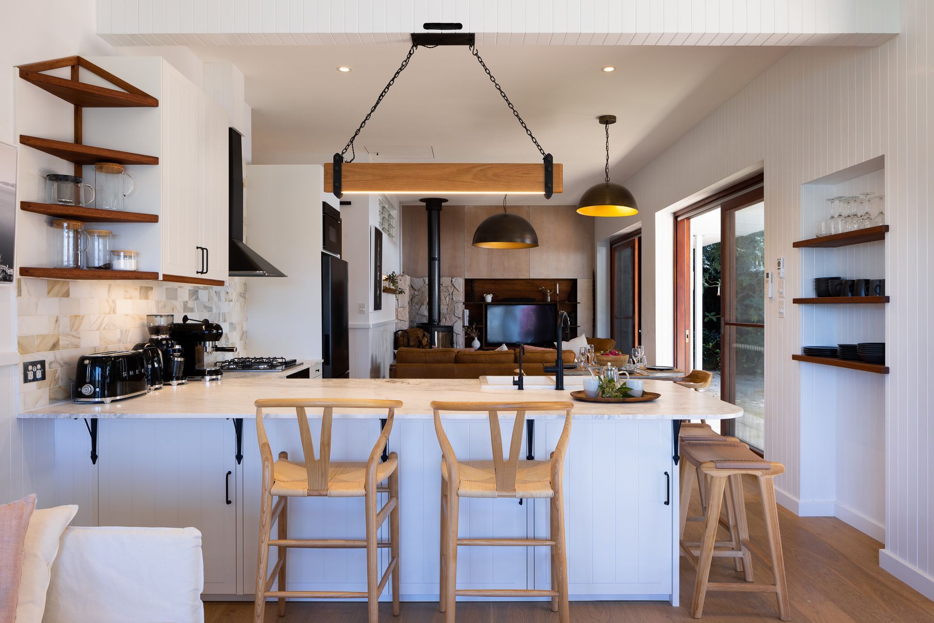 A kitchen with white cabinets and wooden stools