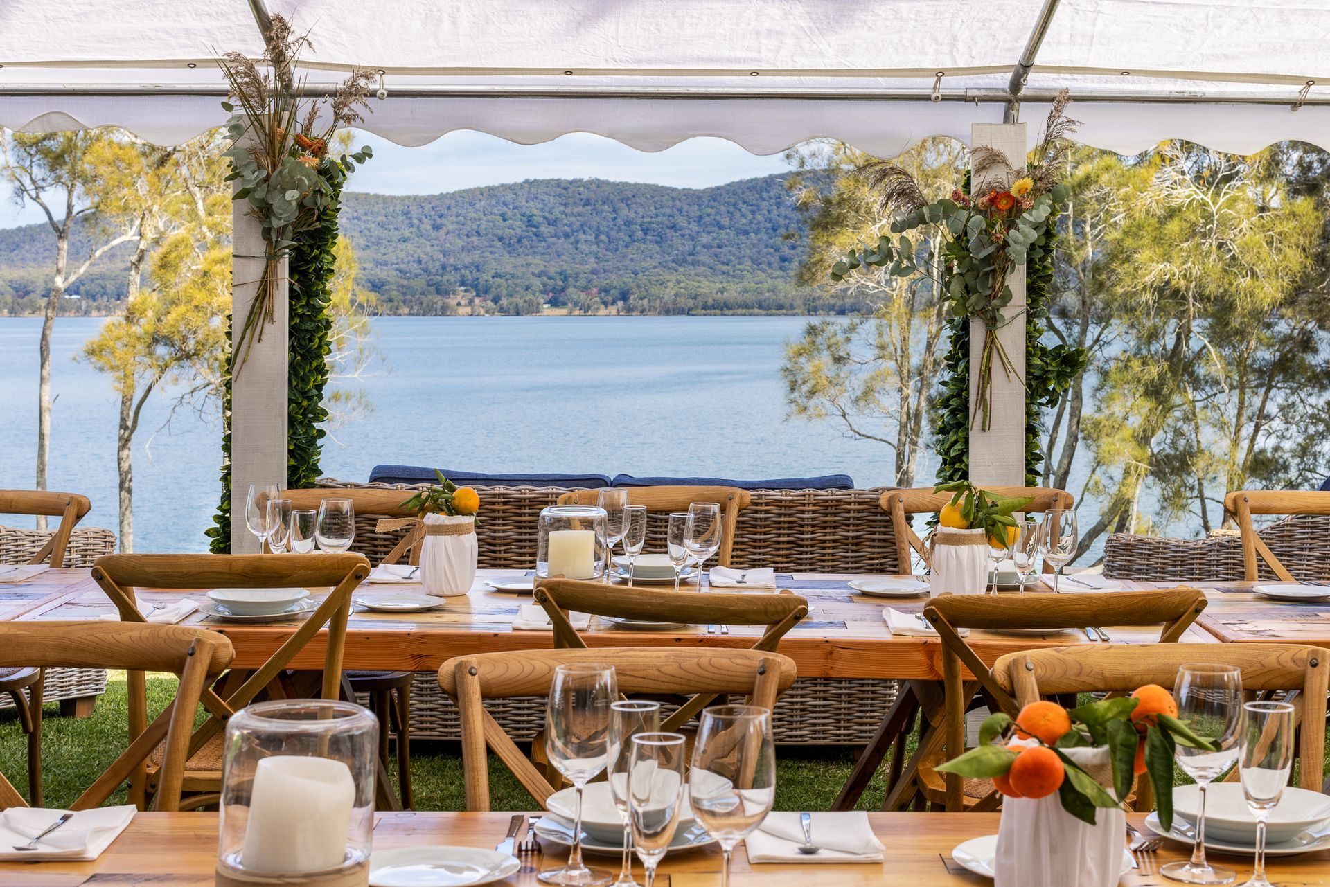 A table set for a wedding reception with a view of a lake.