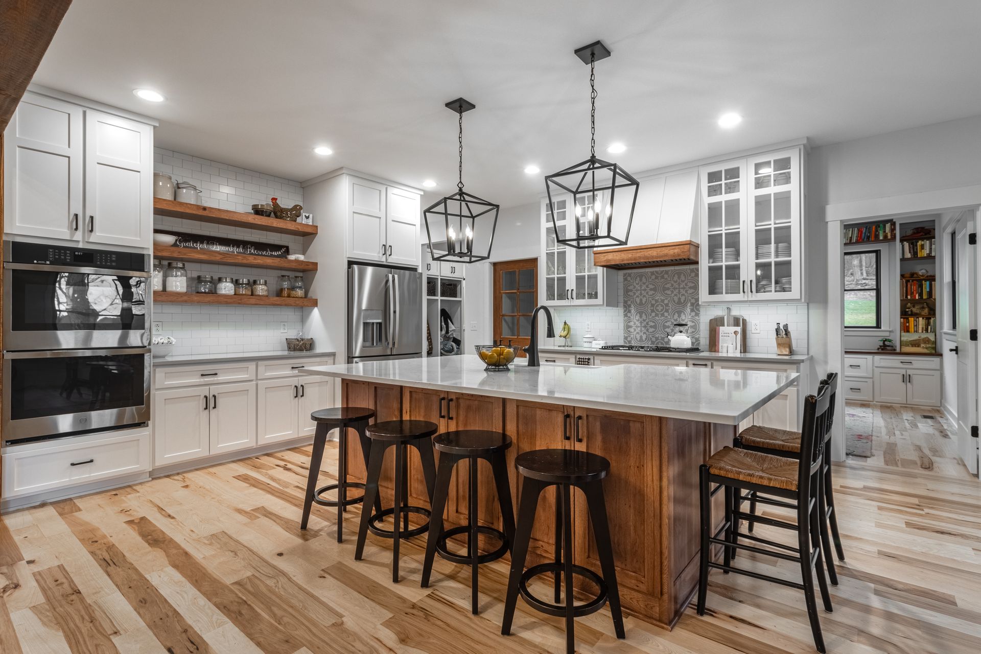 Custom kitchen in State College home with wooden cabinets, open wooden shelving, custom island 