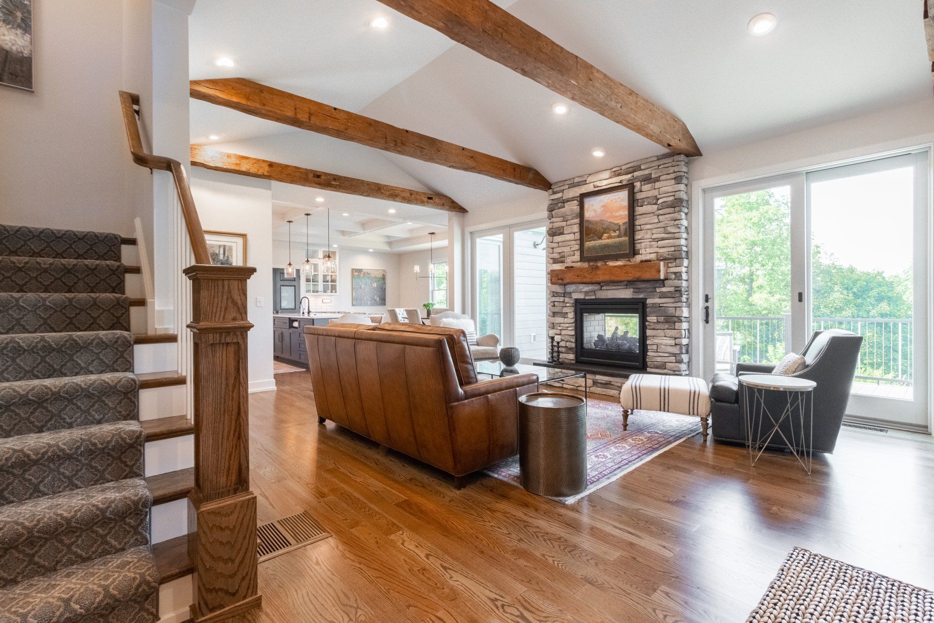 Open concept living room with reclaimed lumber beams in custom home State College, PA