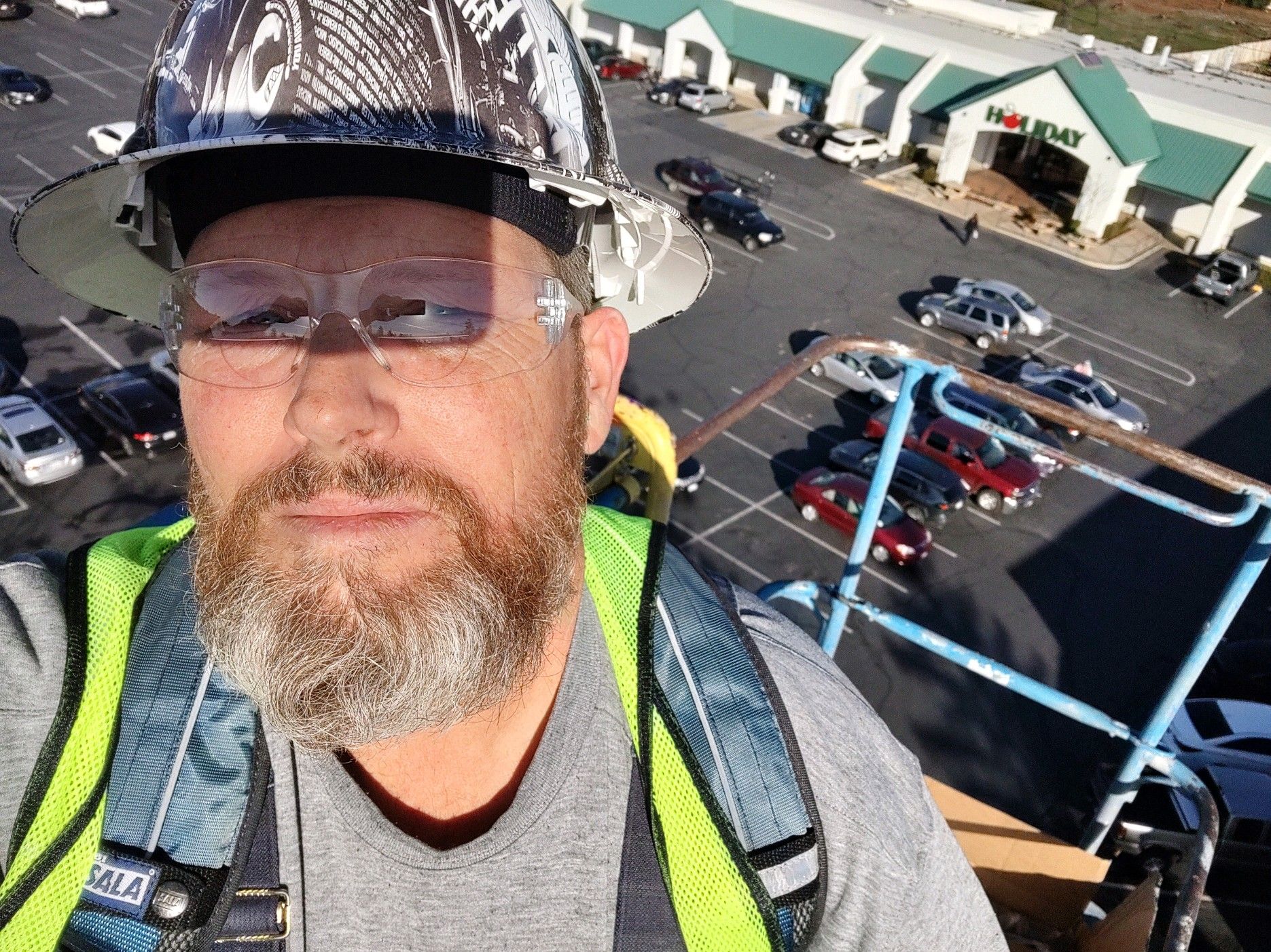 A man with a beard wearing a hard hat and safety vest