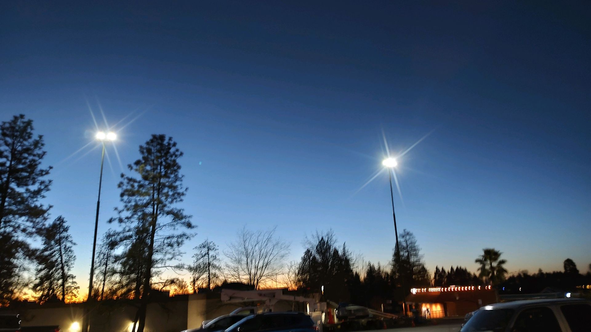 A car is parked in a parking lot at night.