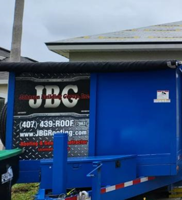 The logo'd dumpster for cleanup during roofing services by JBG Roofing in Kissimmee, FL