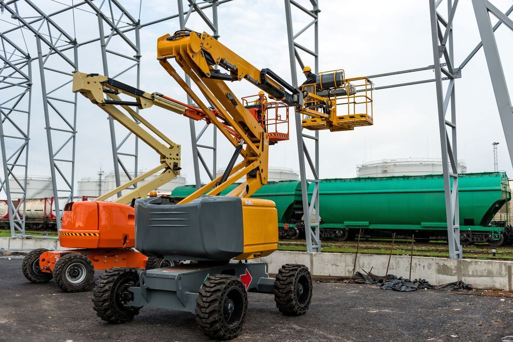 A Yellow and Orange Aerial Lift Is Parked in Front of A Building — PEPS Machinery Services In Logan, QLD