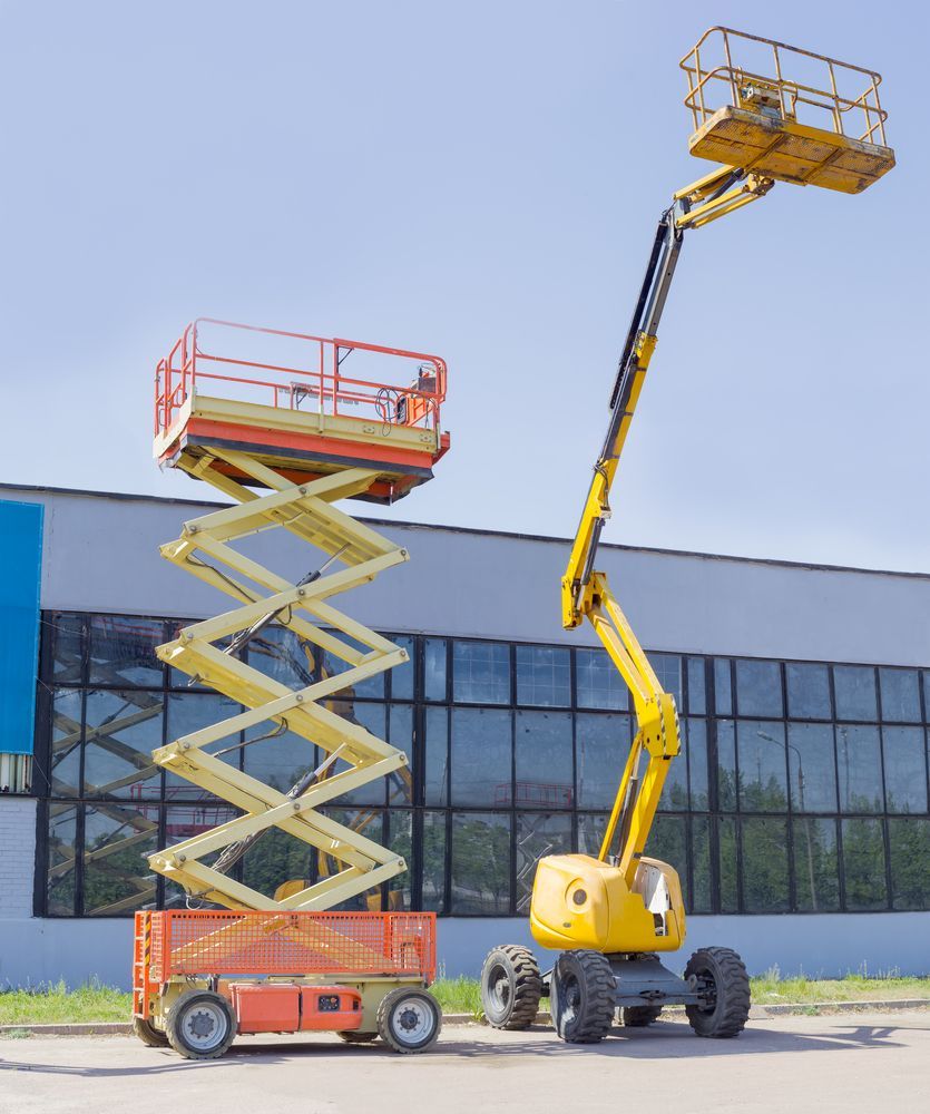 Two Scissor Lifts Are Parked in Front of A Building — PEPS Machinery Services In Bethania, QLD