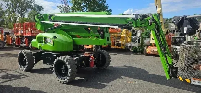 A Green Aerial Lift Is Parked in A Parking Lot — PEPS Machinery Services In Bethania, QLD