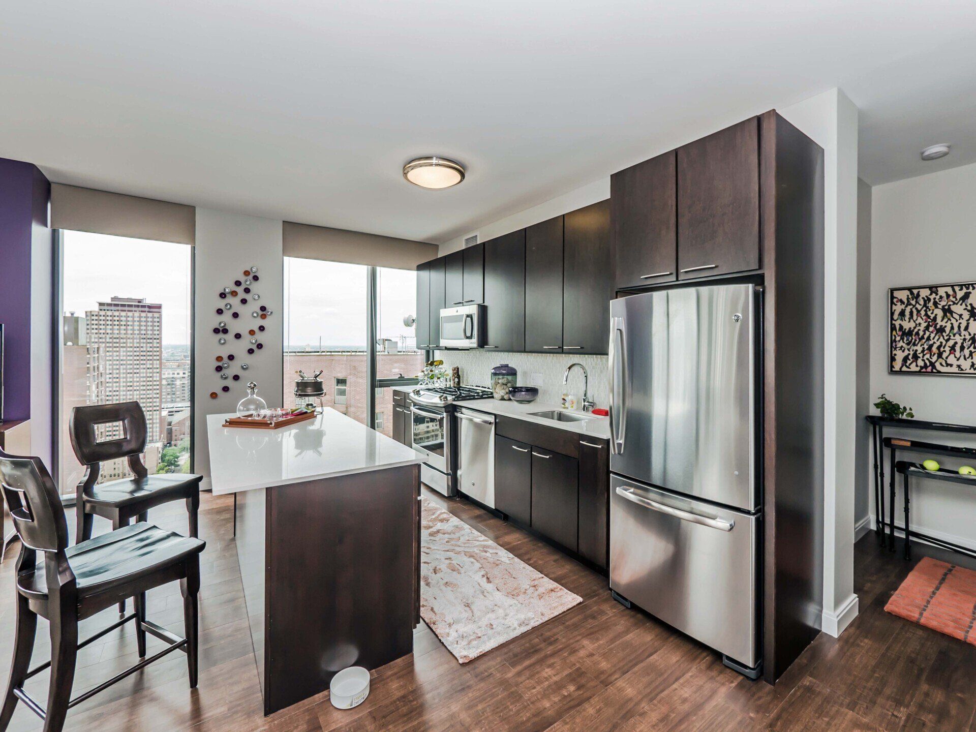 A kitchen with stainless steel appliances and wooden cabinets at State & Chestnut.