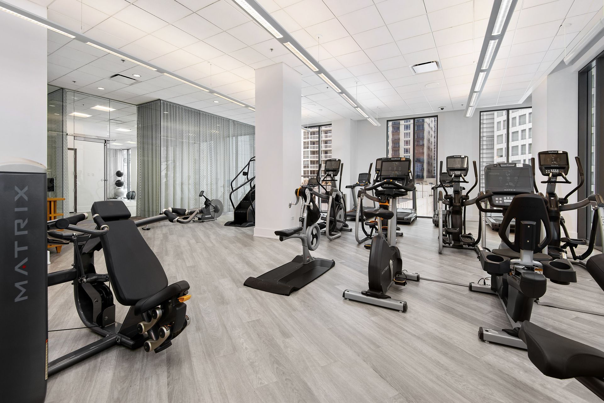 A large gym filled with lots of exercise equipment.