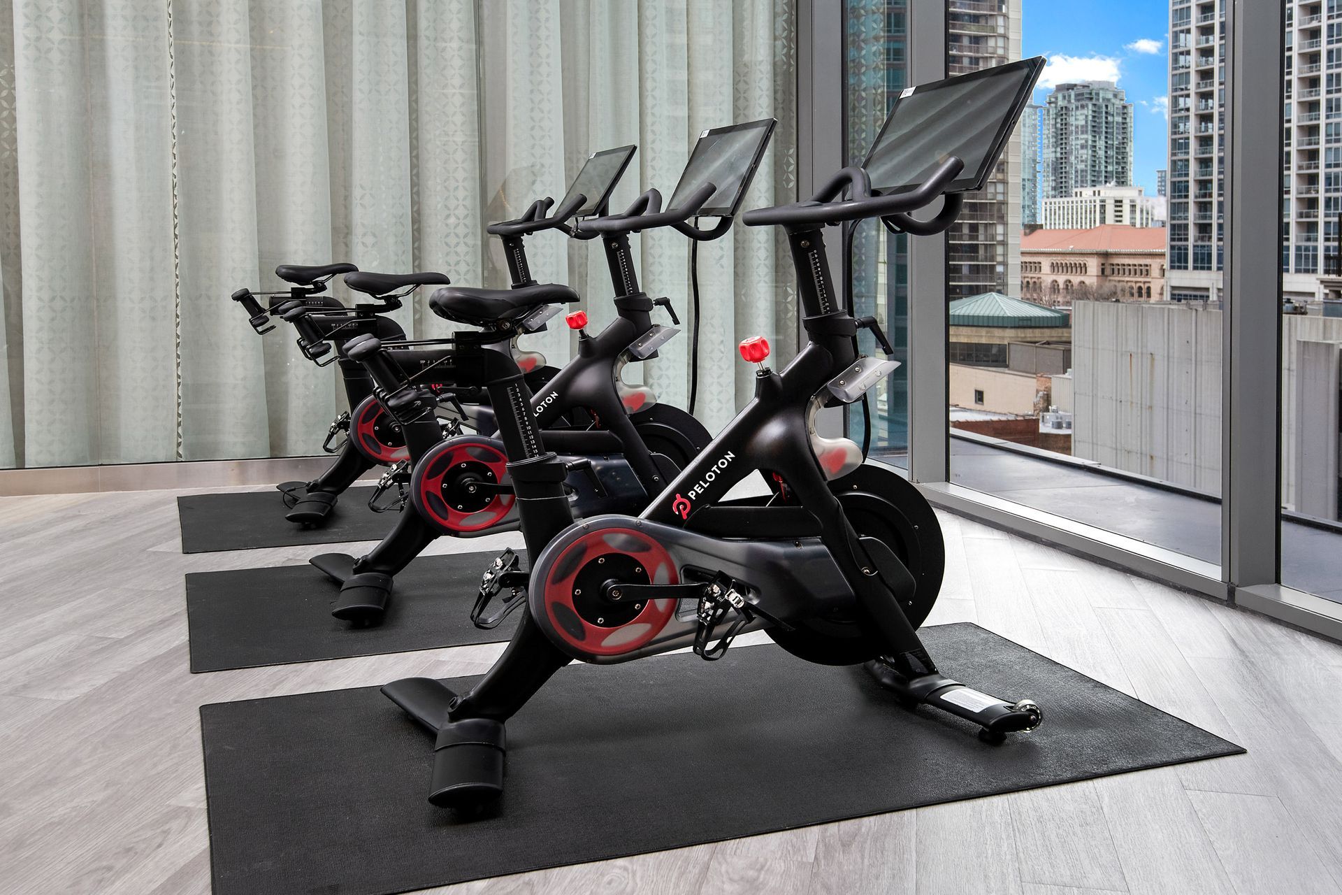 A row of exercise bikes are lined up in a gym.