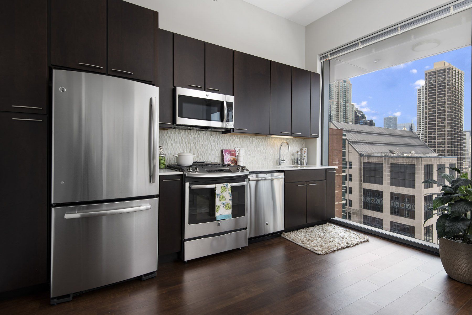 A kitchen with stainless steel appliances and brown cabinets at State & Chestnut.