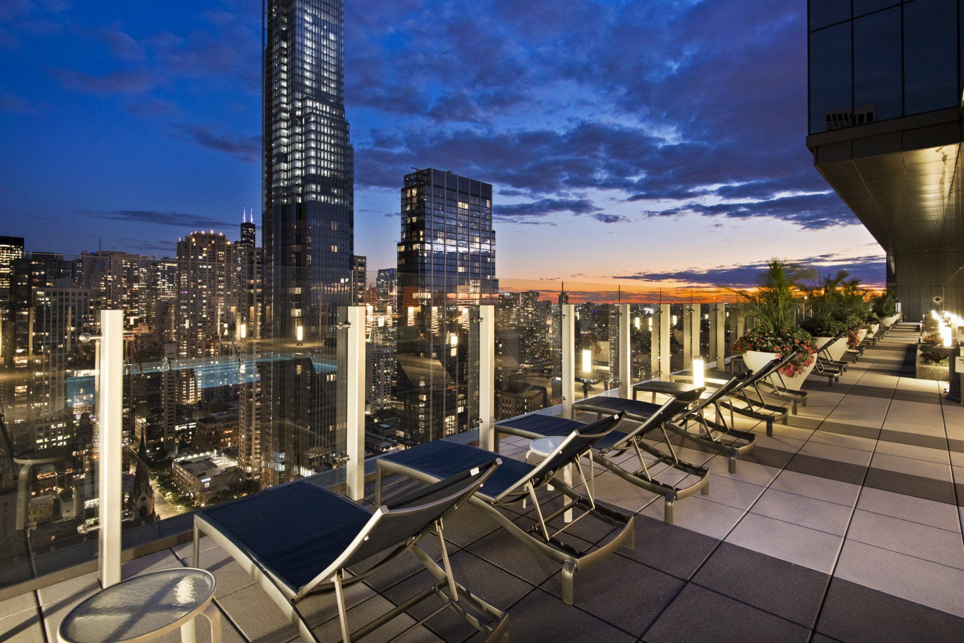A rooftop deck with a view of the city at night at State & Chestnut.