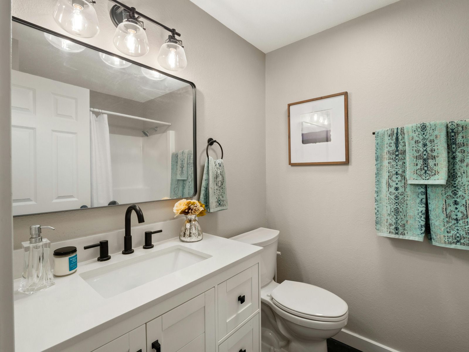 A bathroom with a sink , toilet and mirror.