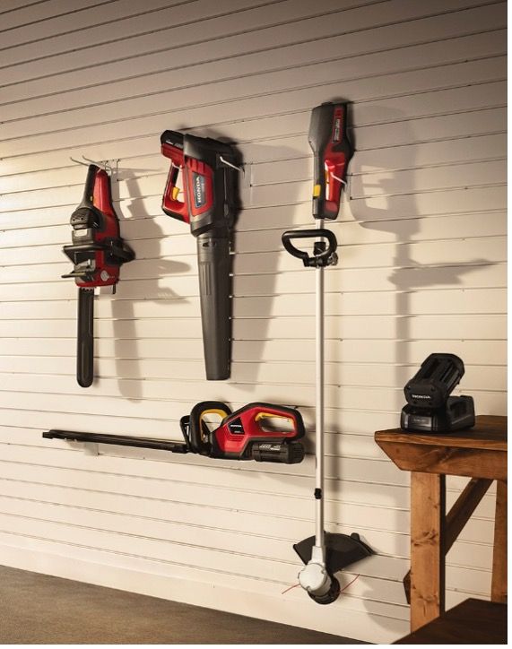 A bunch of tools are hanging on a wall in a garage  — Terrace Mowers in Raymond Terrace, NSW