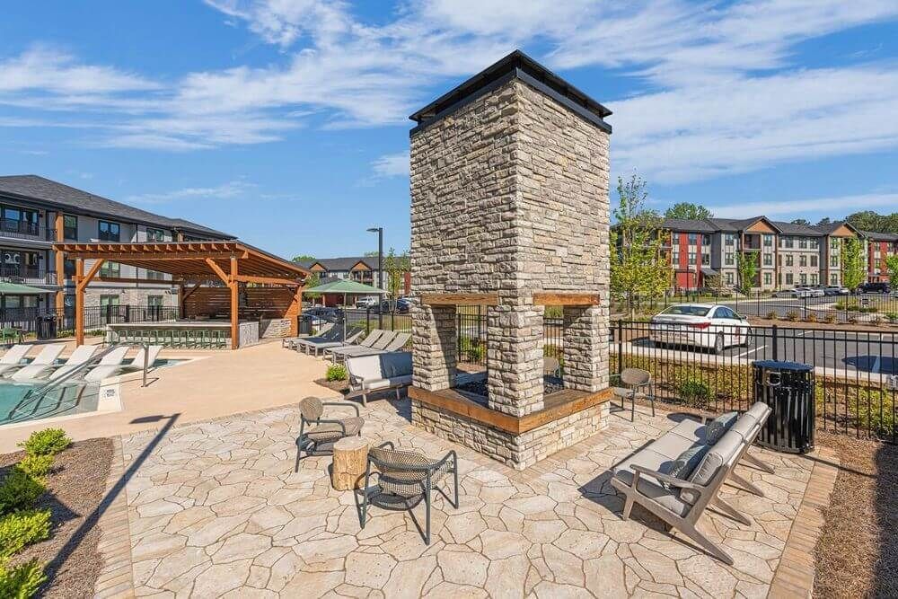 There is a stone fireplace in the middle of the patio area.