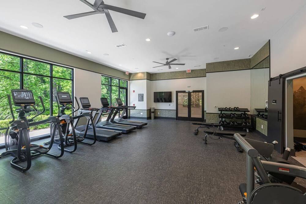 A large gym with a lot of treadmills and exercise bikes.