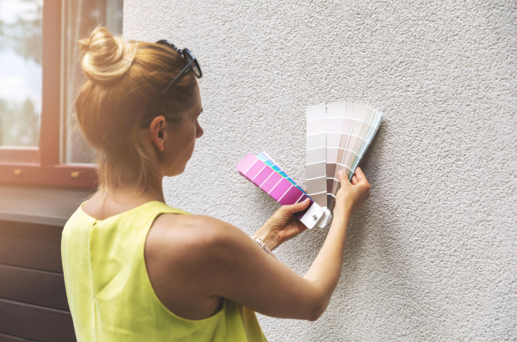 “Worker holding color samples and applying texture to an exterior wall during a stucco service in Spring Valley, NV”