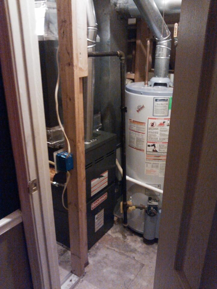 A room with a water heater and an air conditioner