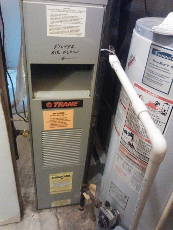 A trane air conditioner is next to a water heater