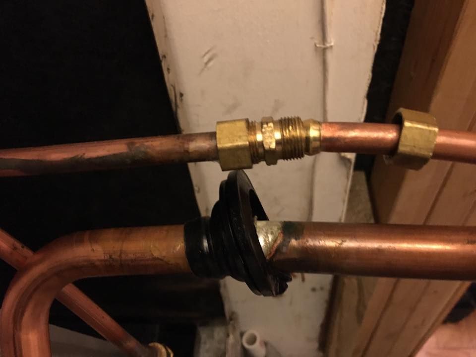 Two copper pipes are connected to each other with brass fittings