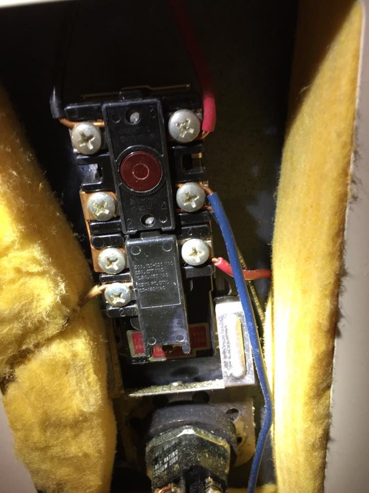 A close up of a thermostat with wires coming out of it.