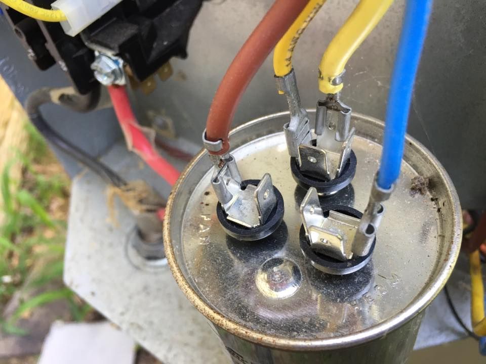A close up of a capacitor with wires attached to it