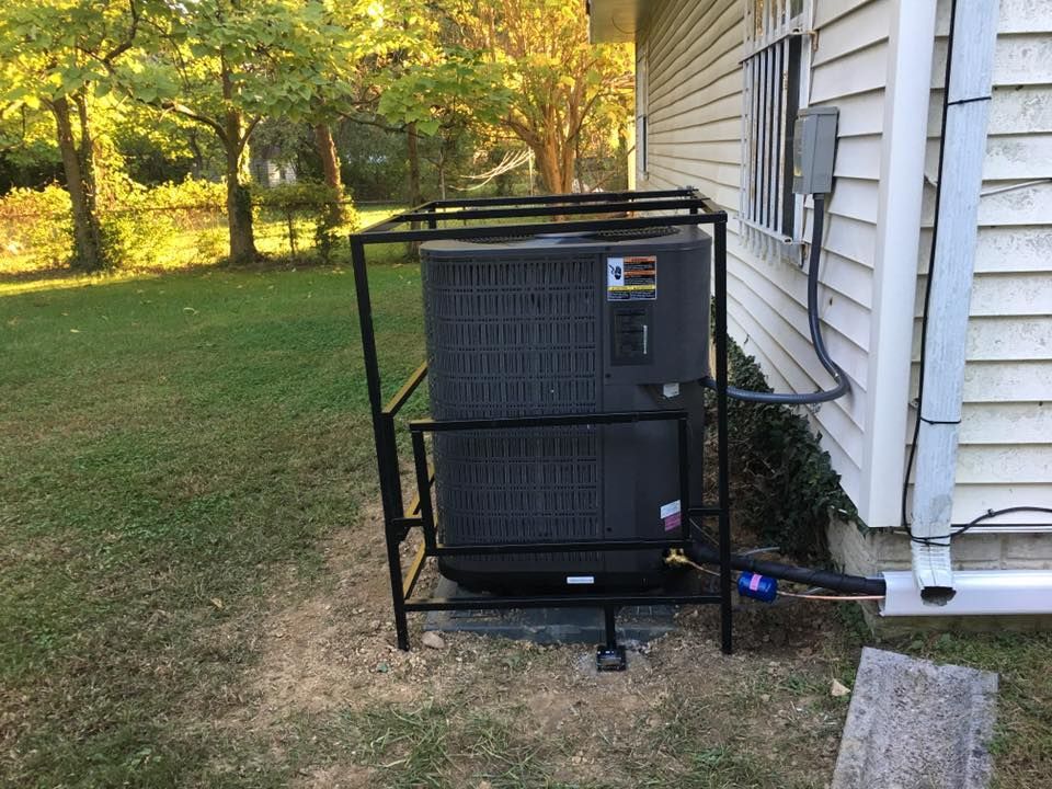 An air conditioner is sitting on the side of a house.