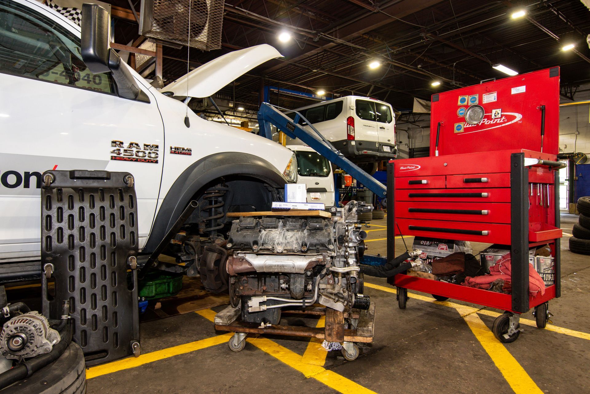 Truck repair shop interior; a truck being worked on, engine on a cart, and tools in a red toolbox | Freestate Auto & Truck Service