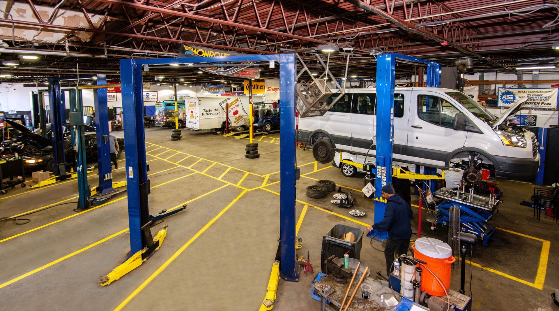 A mechanic workshop with a van on a lift. Yellow lines mark work areas | Freestate Auto & Truck Service