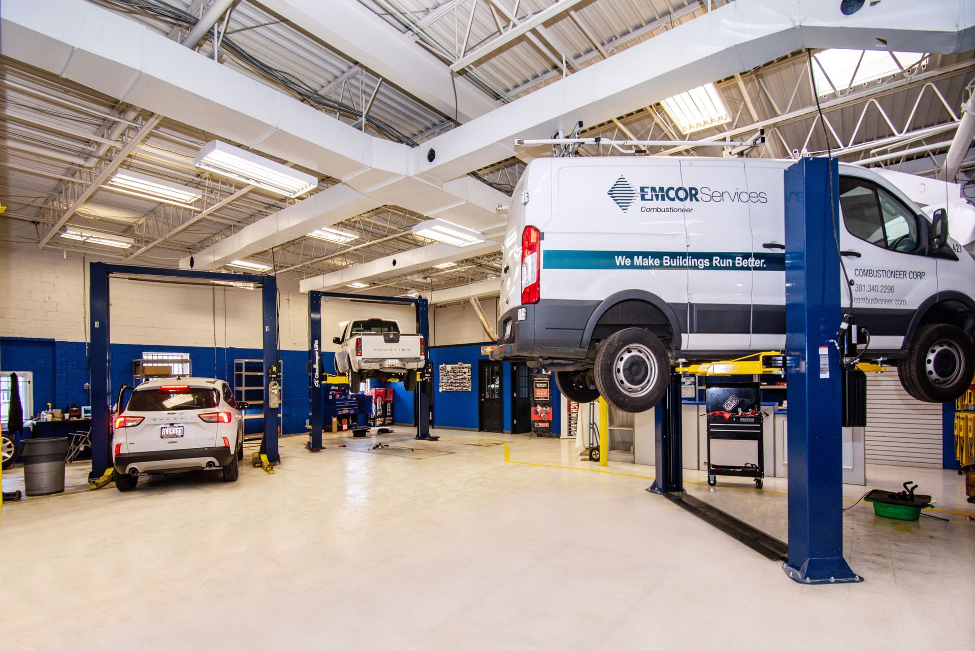 Auto repair shop interior with vehicles on lifts; blue and white color scheme | Freestate Auto & Truck Service